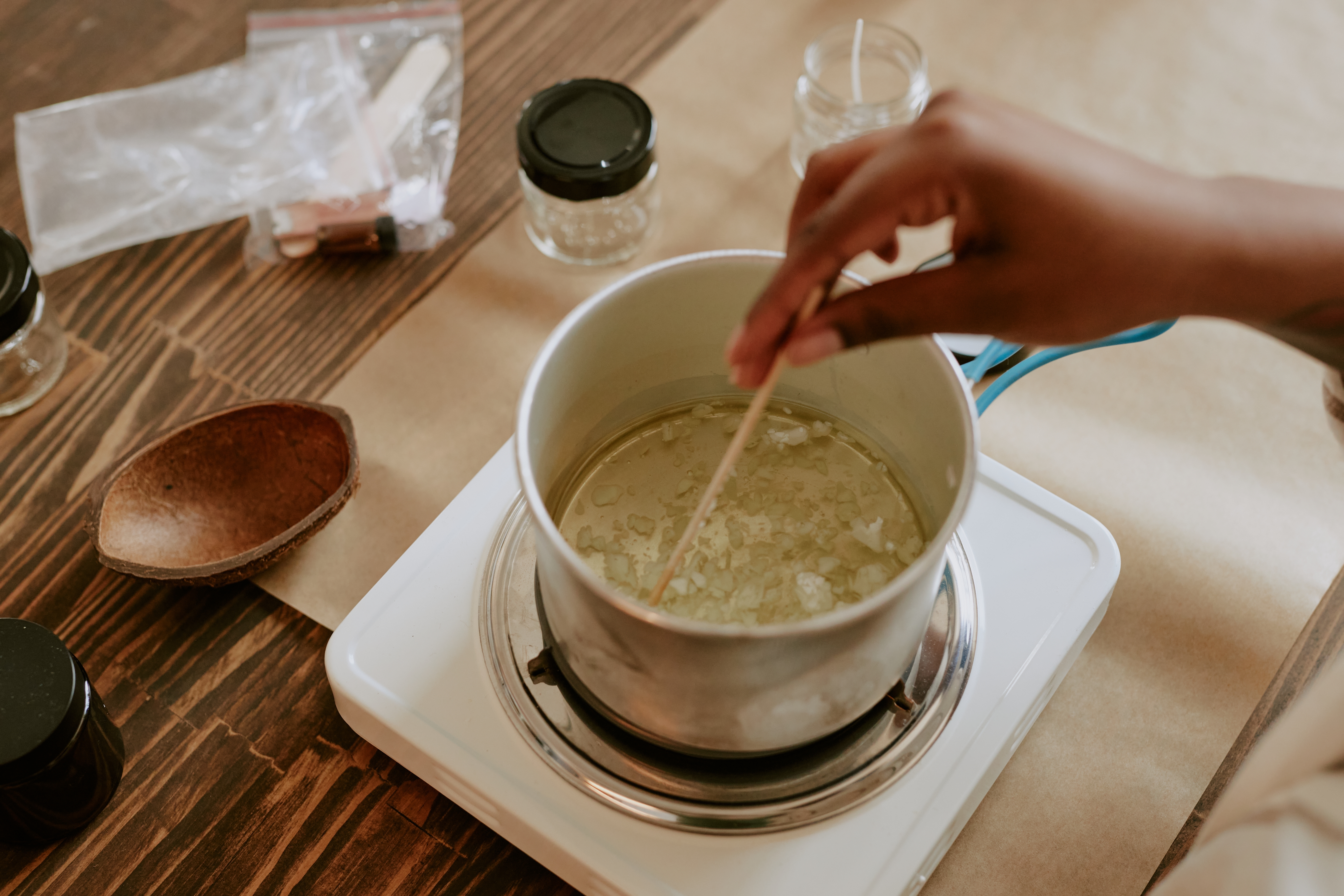 Hand stirring a pot with a wooden spoon