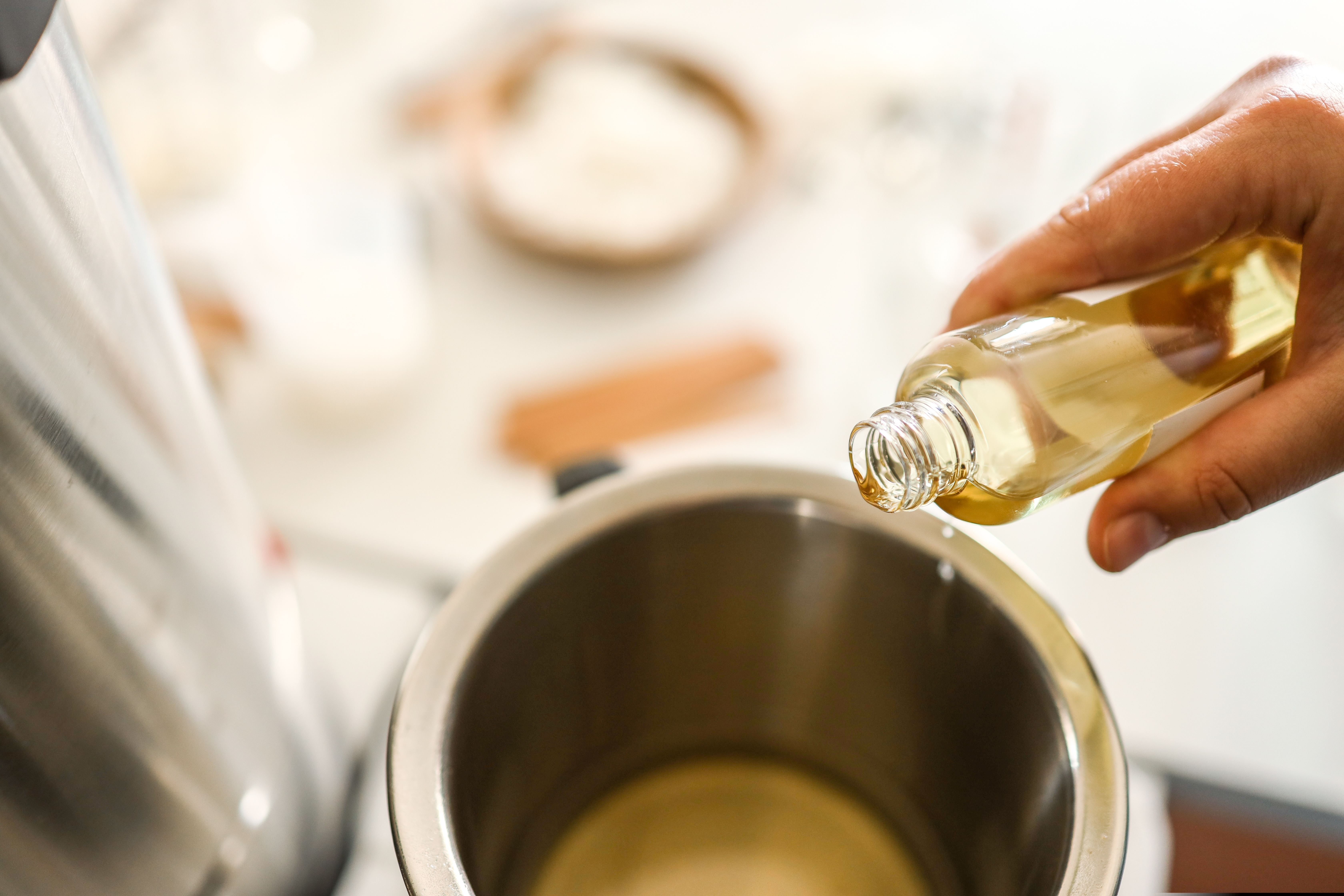 glass bottle pouring oil into a wax warmer