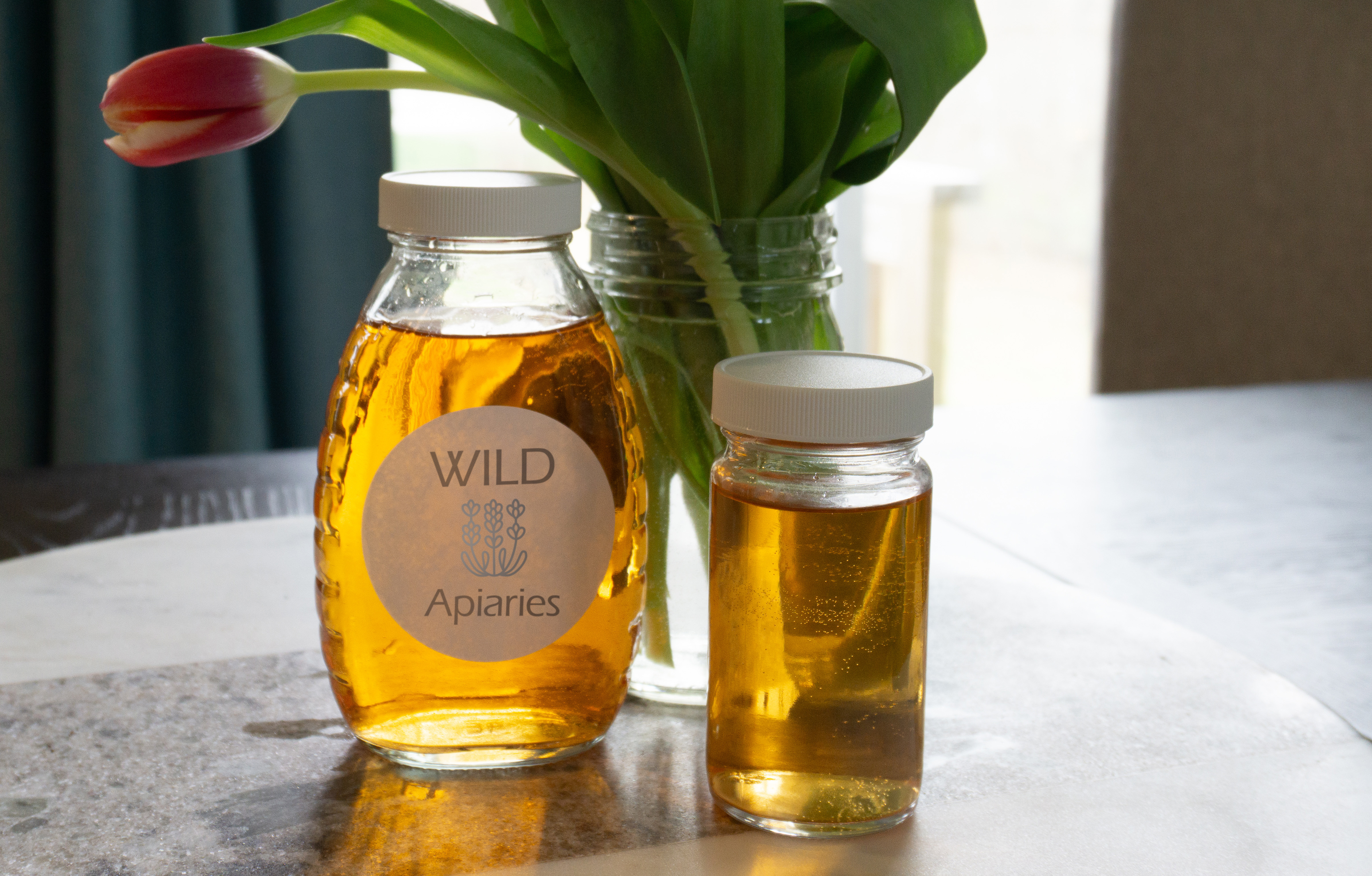 Two glass honey jars on a table