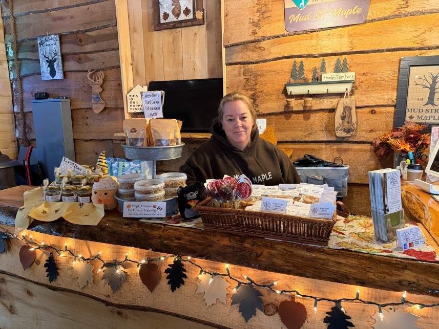 Robin Mahler standing behind a counter full of maple products