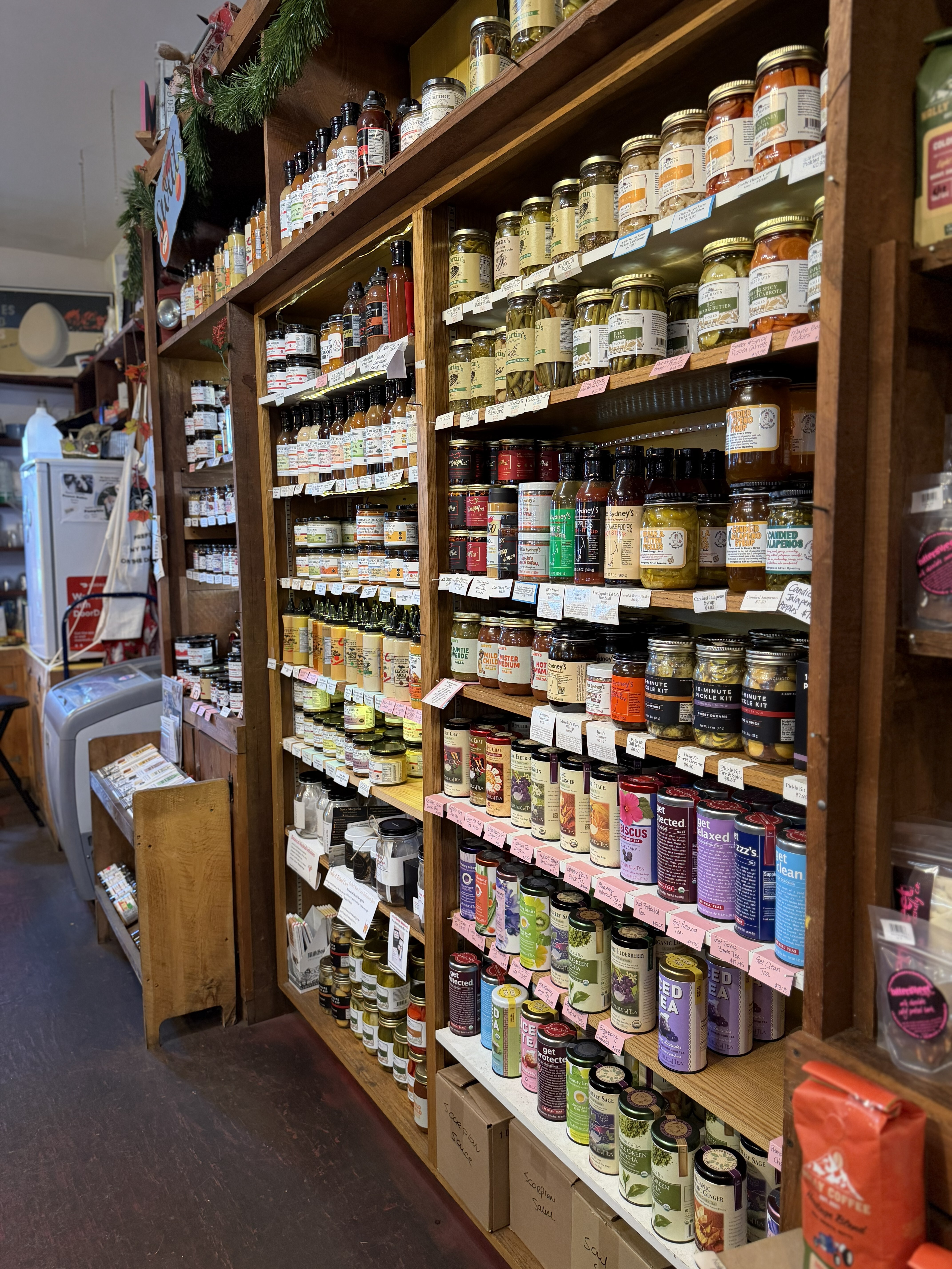 A wall of wooden shelves full of canned goods